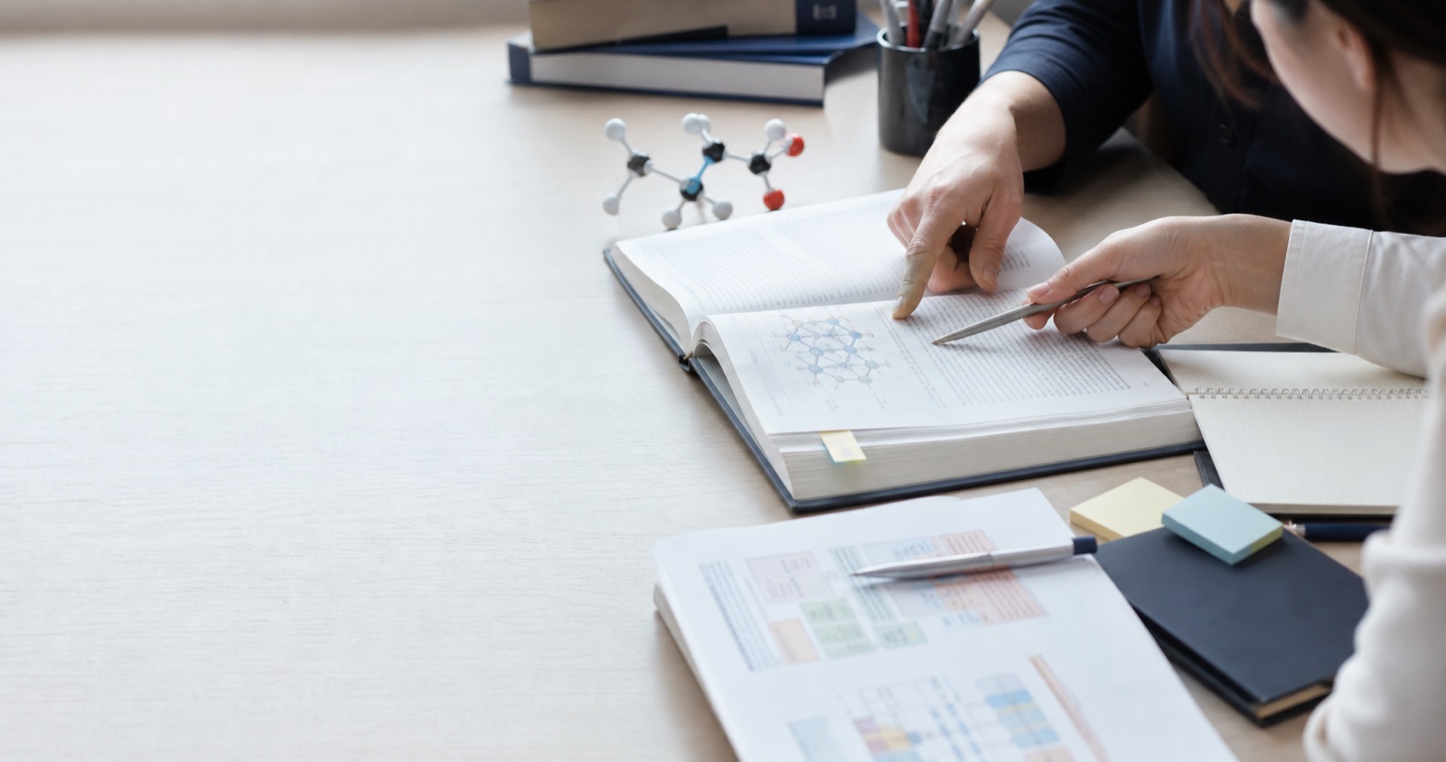 薬学の専門書と分子模型を使った個別指導のイメージ