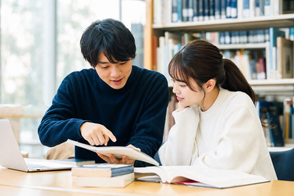 先輩男子学生が後輩女子学生に助言する指導風景