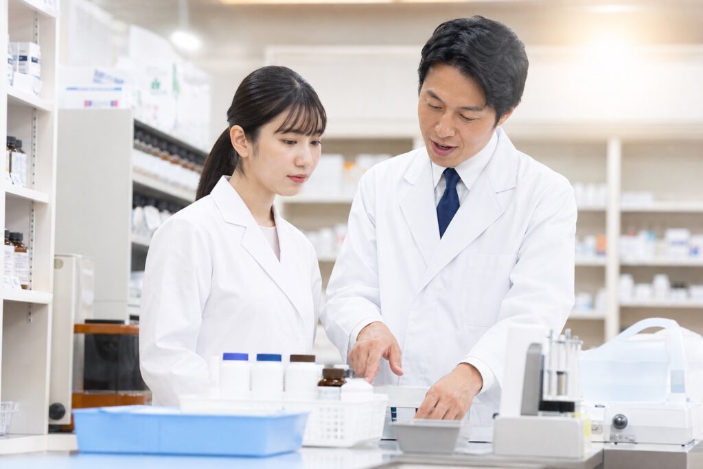 白衣の学生が実習で指導者から指導を受ける様子